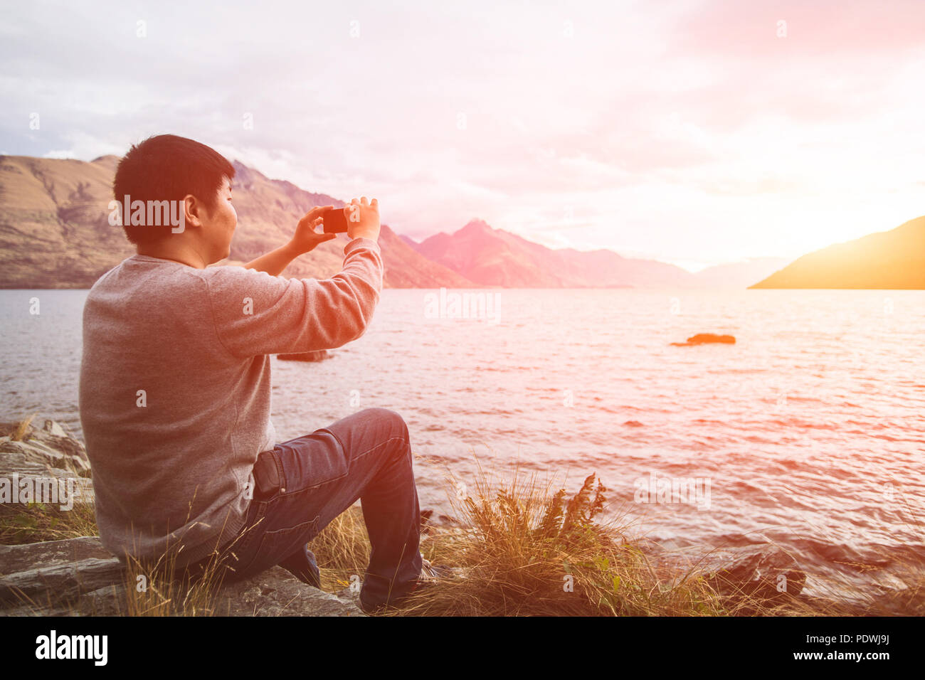 Jeune Homme Faire De Photo De Coucher De Soleil Sur Le