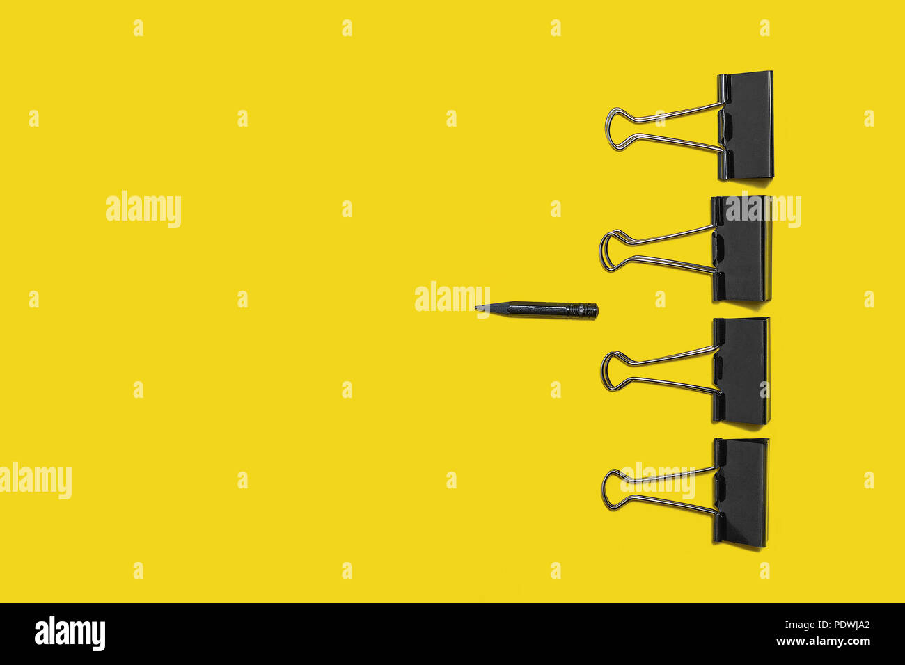 Quatre gros trombones contre petit crayon Banque D'Images