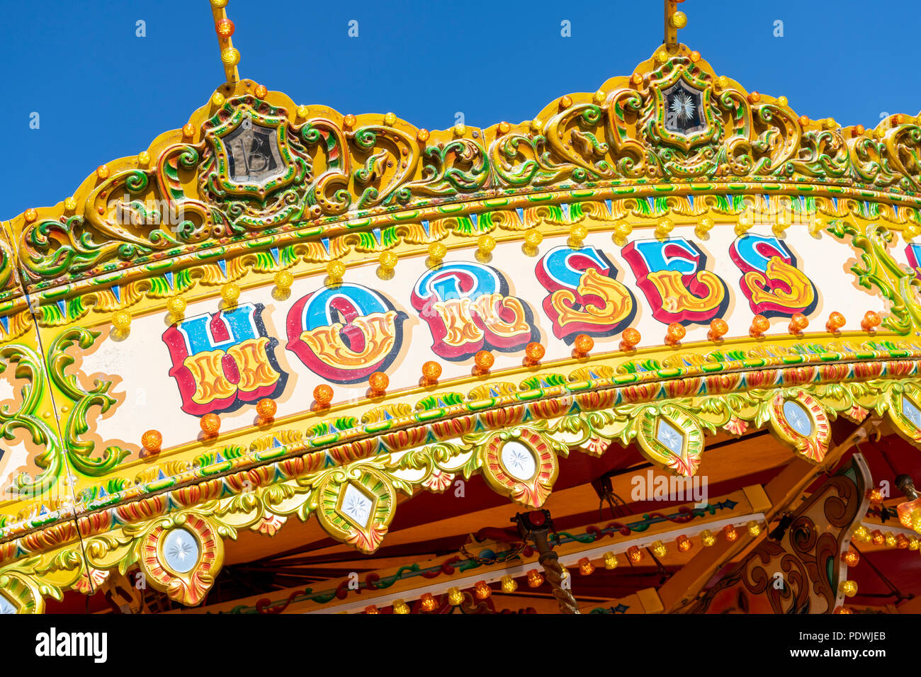 Un gros plan d'un carrousel de chevaux galopant coourful ou rond-point à une fête foraine au Royaume-Uni en été Banque D'Images