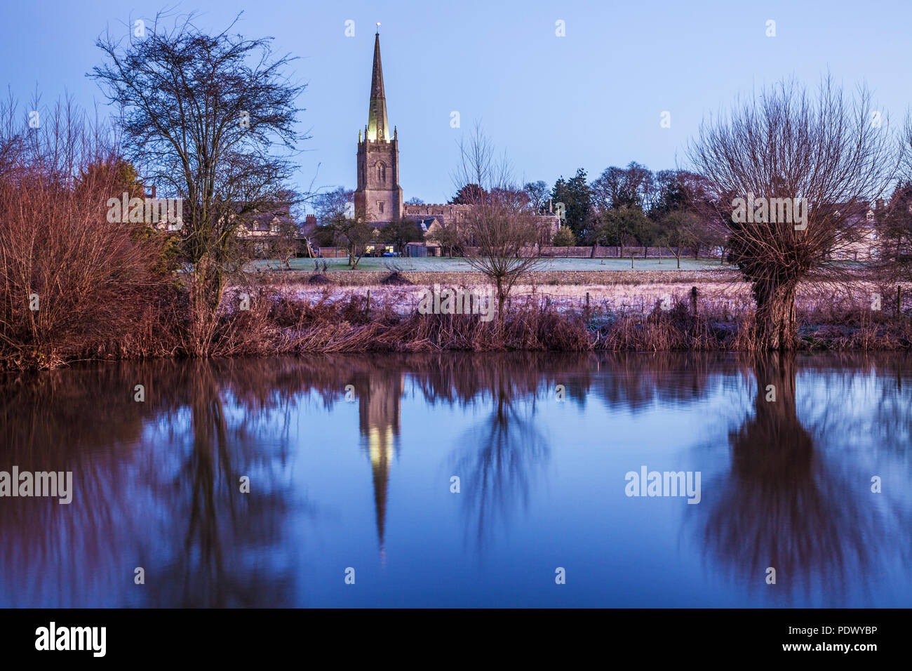 L'église Saint-Laurent à Lechlade reflète dans la Tamise au crépuscule. Banque D'Images