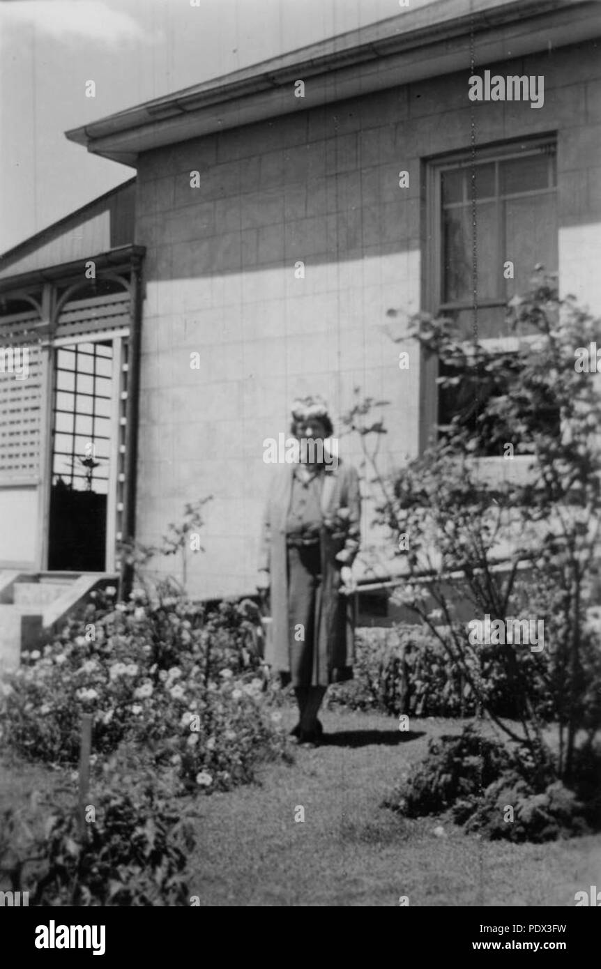 247 1 192831 StateLibQld Lillian Irving debout dans le jardin à Pahroombin, Bowen Hills, ca. 1940 Banque D'Images