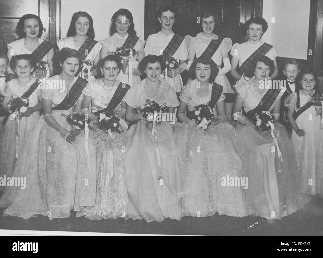 262 1 296739 StateLibQld Debutantes holding bouquets à une danse sociale, 1952 Banque D'Images