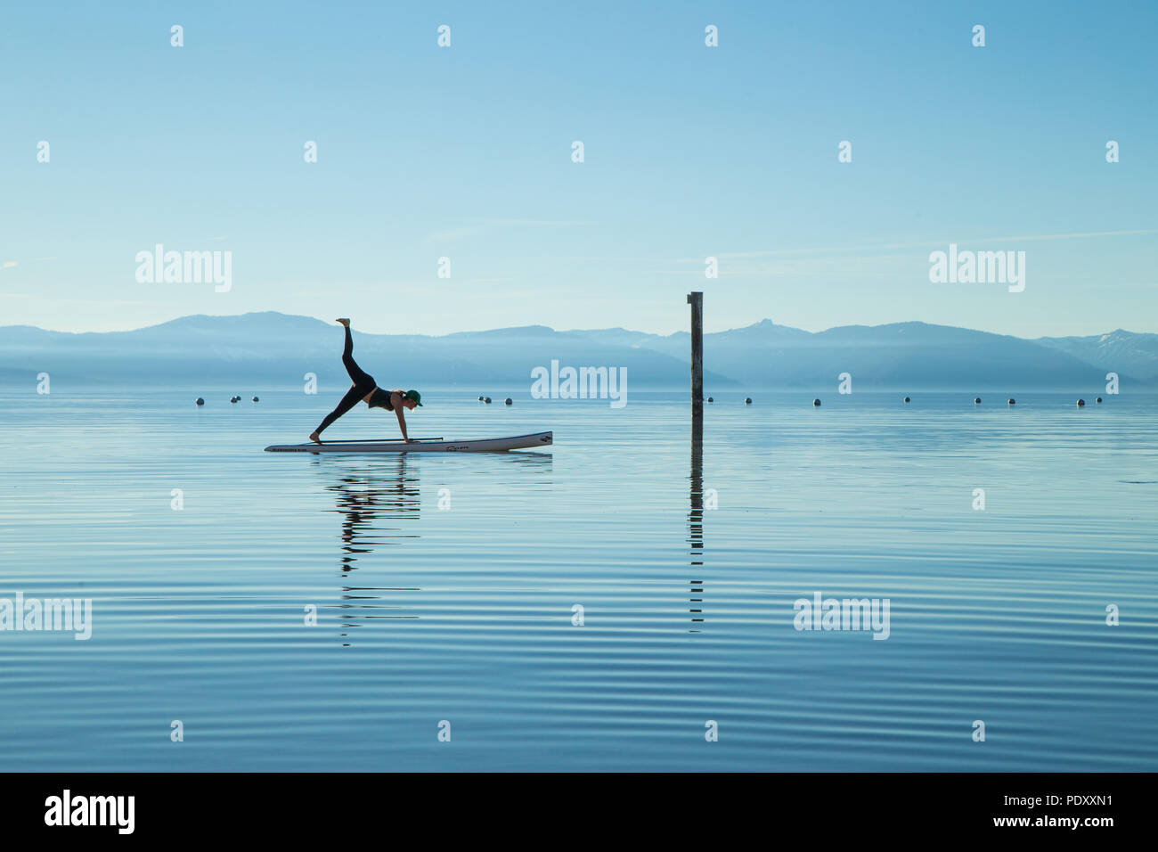 Woman in Yoga Pose on Paddle Board sur Lake, Lake Tahoe, Nevada, USA Banque D'Images