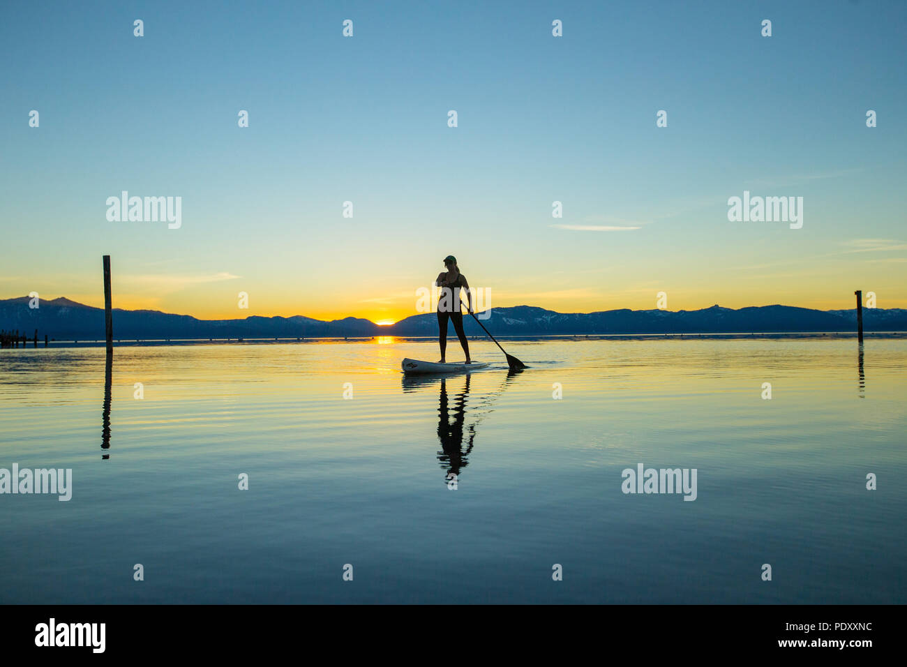 Woman on Paddle Board au coucher du soleil, le lac Tahoe, Nevada, USA Banque D'Images