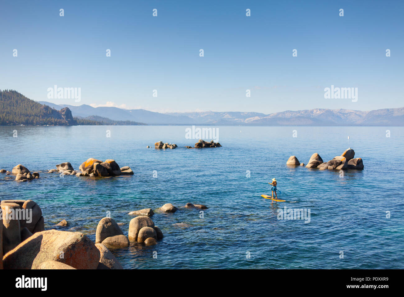 Par la pagaie femme côte rocheuse, Lake Tahoe, Nevada, USA Banque D'Images