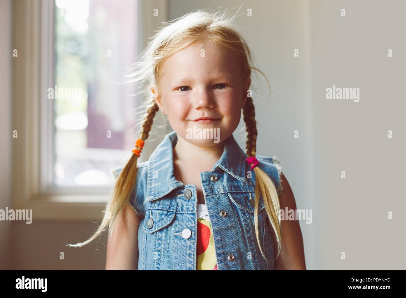 Closeup portrait of cute adorable blonde Woman smiling girl à huis clos. La fille aux cheveux de lumière avec tresses, portant des pays Banque D'Images