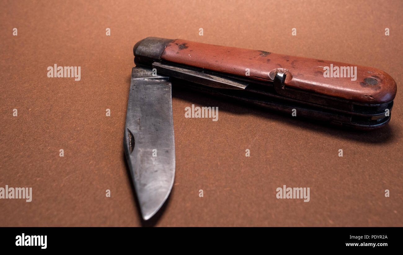 Antique vintage couteau de poche militaire suisse avec utilisé et Rusty seconde guerre mondiale blade brown background Banque D'Images
