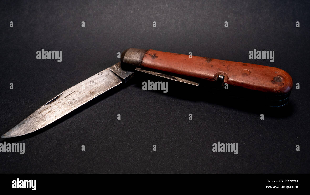 Antique vintage militaire suisse couteau de poche avec lame rouillée et utilisé à partir de la seconde guerre mondiale, Fond en cuir noir Banque D'Images