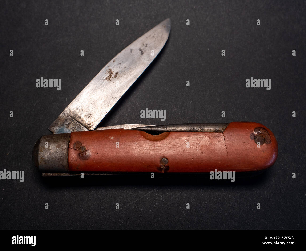 Antique vintage militaire suisse couteau de poche avec lame rouillée et utilisé à partir de la seconde guerre mondiale, Fond en cuir noir Banque D'Images