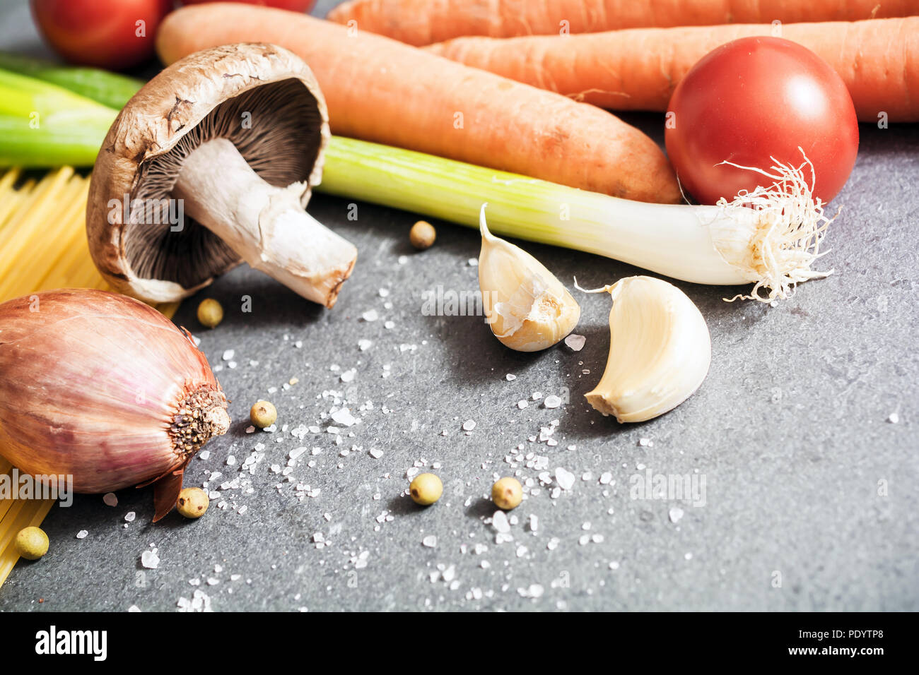 Cuisine des ingrédients comme l'oignon, l'ail, champignons, carottes ou d'épices sur ardoise Banque D'Images