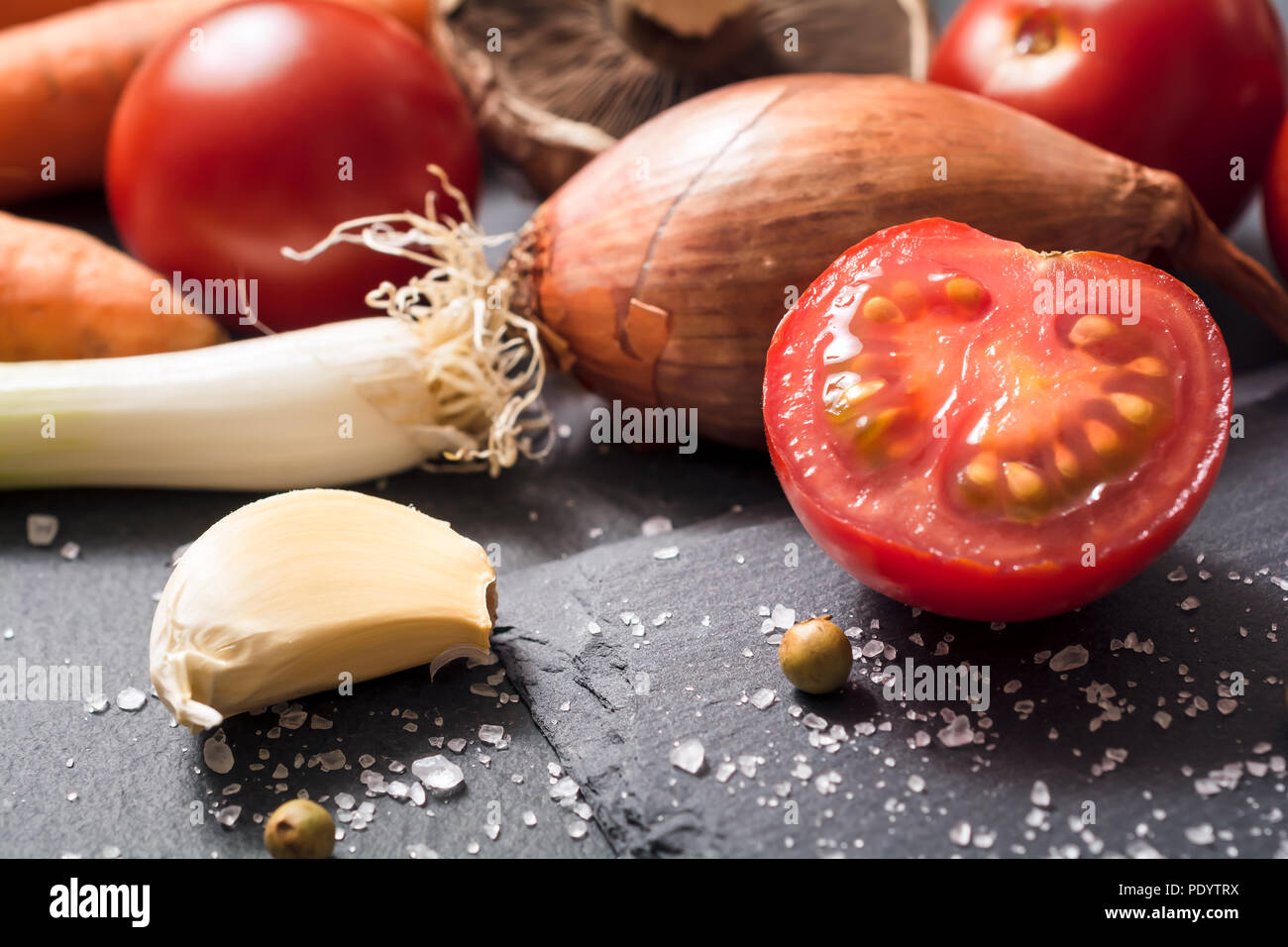 Ingrédients de cuisine comme les tomates, l'ail, l'oignon ou d'épices sur ardoise Banque D'Images