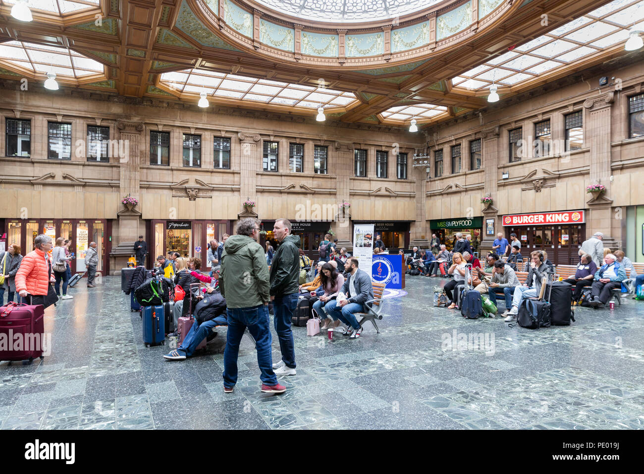 Salle d'attente de la gare Waverley d'Édimbourg et d'attente des voyageurs assis Banque D'Images