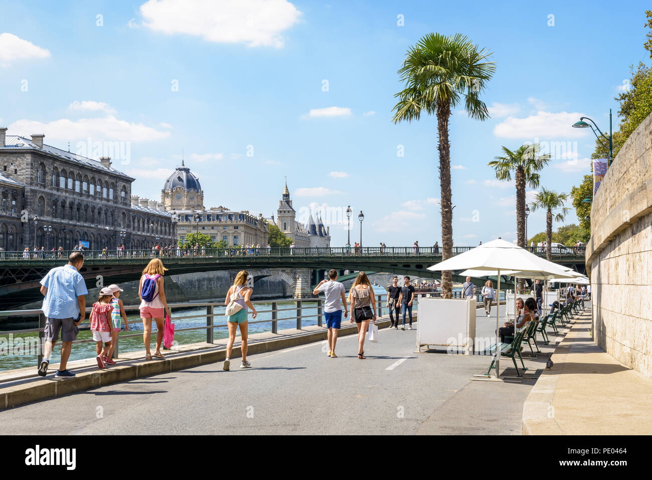 Les gens se promener et faire du vélo sur les bords de la Seine au cours d'événement Paris-Plages, auprès du tribunal de commerce et le Palais de la Cité à l'arrière-plan Banque D'Images