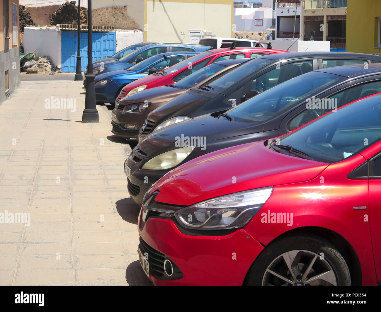 Rangée de petites voitures à hayon garée à côté de la rue en plein soleil Banque D'Images