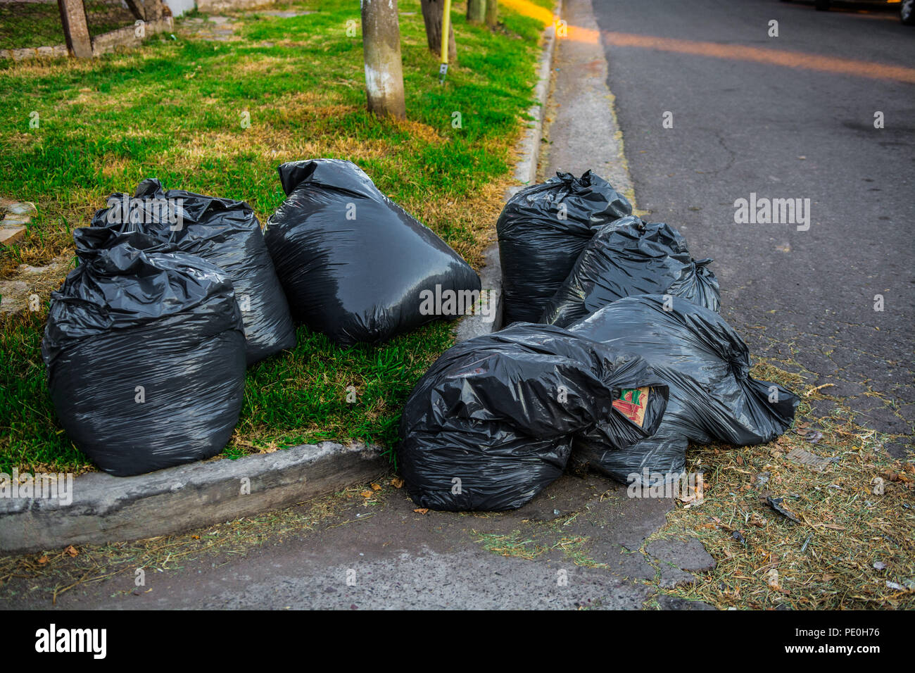 Pile de sacs poubelle noir dans un coin de rue Photo Stock - Alamy