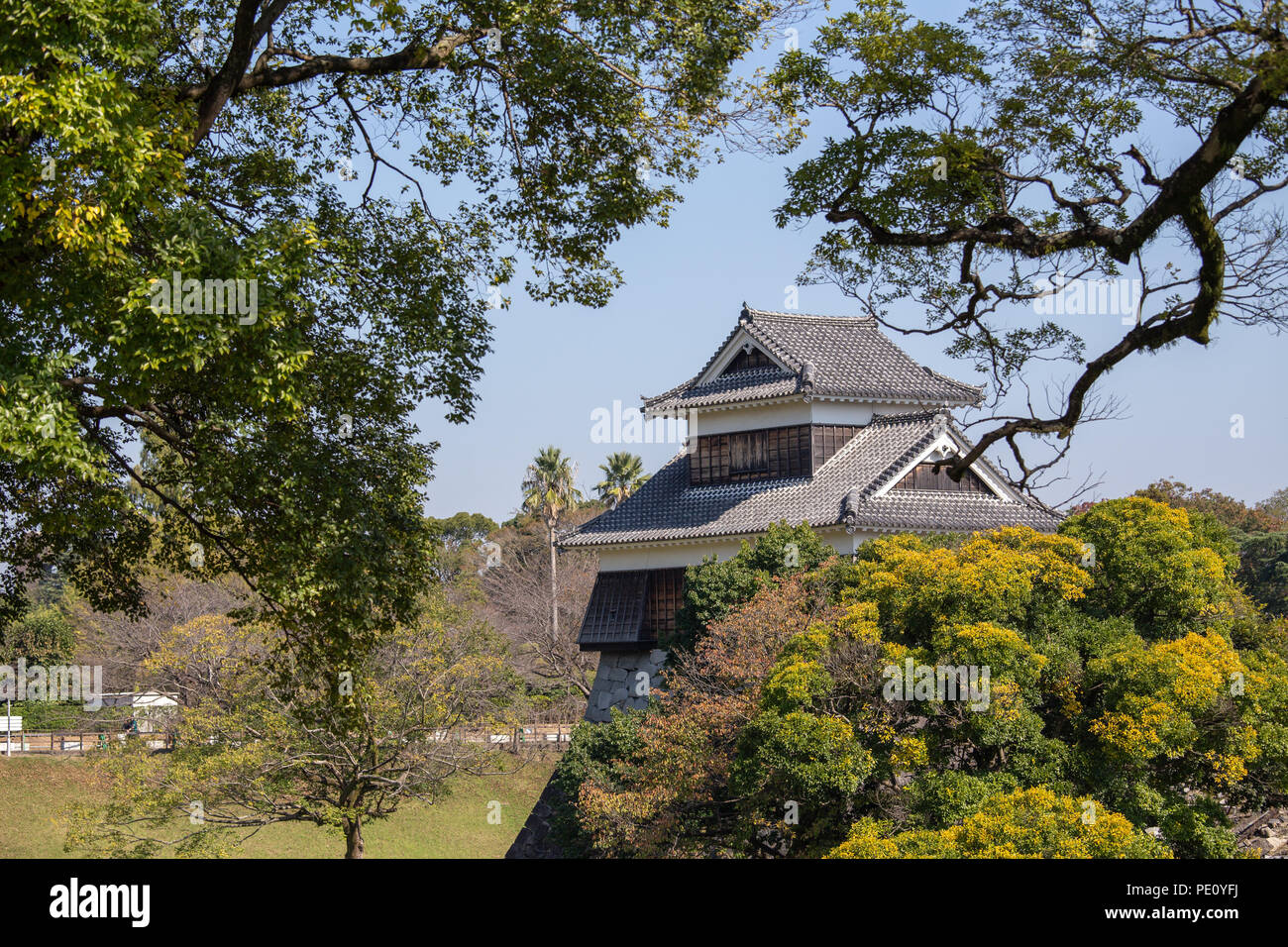 Tourelle en bois ou yagura sur mur de pierre du château de Kumamoto au Japon entourent par arbre vert et bleu ciel avec copie espace Banque D'Images