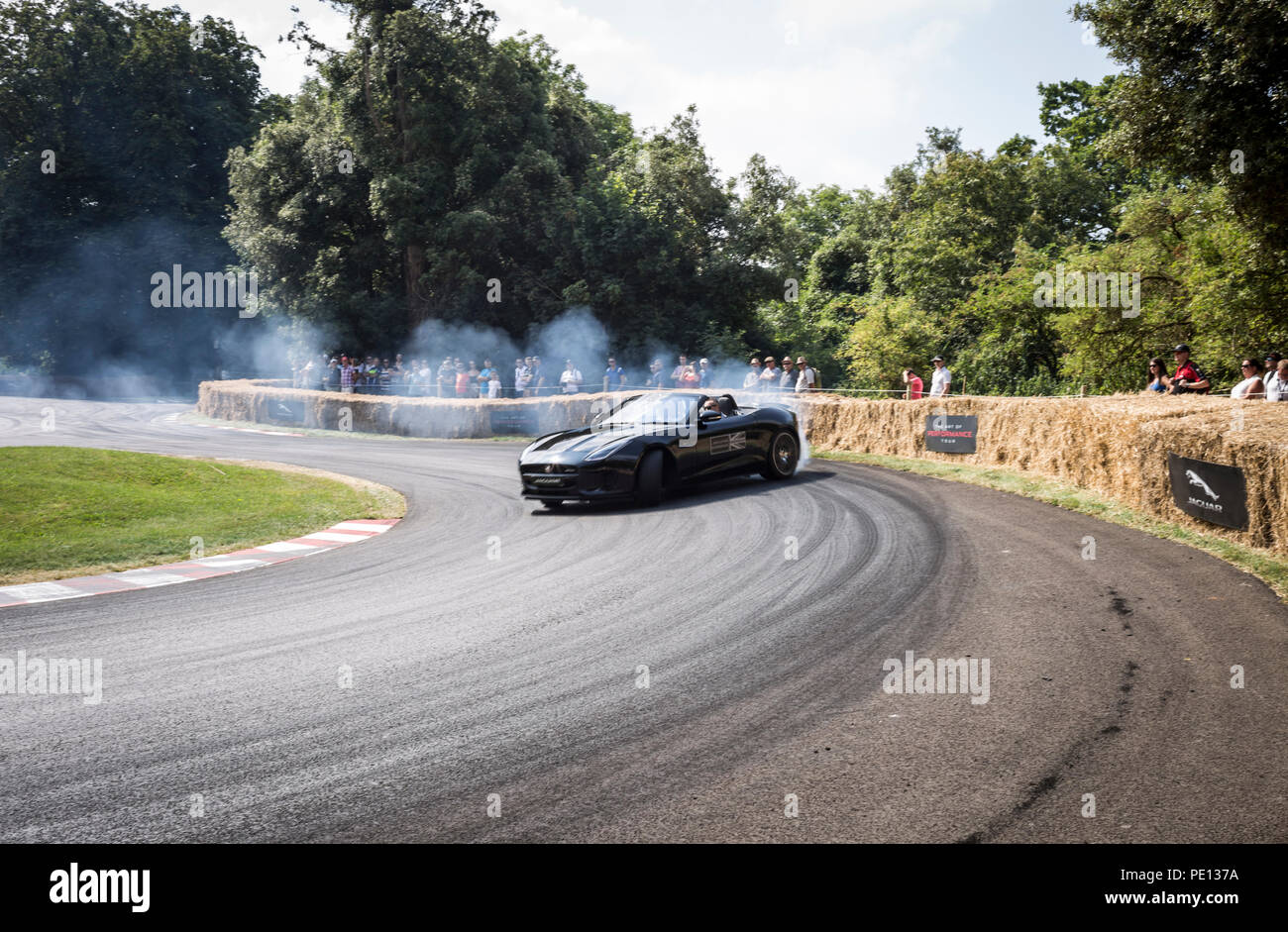 Un cabriolet Jaguar sportscar tourne ses pneus, créant de la fumée, sur une piste à la Goodwood Festival of Speed 2018. Banque D'Images