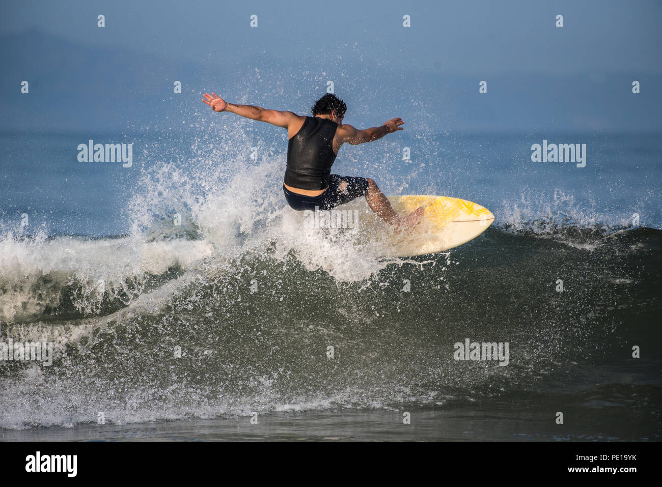 Surfer mâle glisse sur l'onde à travers des initiatives locales et à la section suivante dans l'eau chaude envoyé d'Hurrican John à Ventura, Californie le 11 août, 2 Banque D'Images