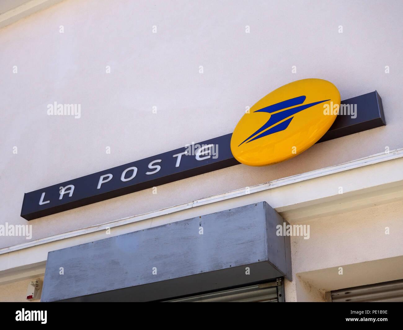 Signe avec nom et logo du bureau de poste sur le mur du service postal dépôt à Cessenon-sur-Orb, France Banque D'Images