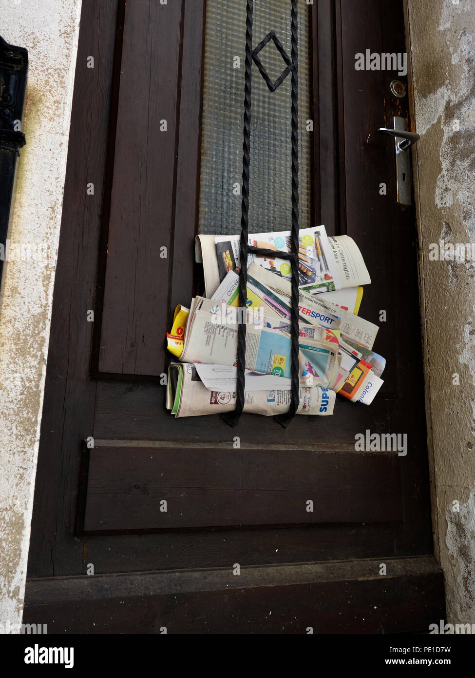 Junk mail laissé coincé dans la porte d'une maison de Cessenon-sur-Orb, France Banque D'Images