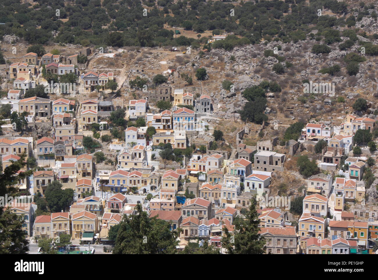 Vue sur les maisons du port de Symi, Grèce. Vue sur la ville d'Ariel avec ses élégants bâtiments classiques. Toits colorés carrelés rouges. Banque D'Images