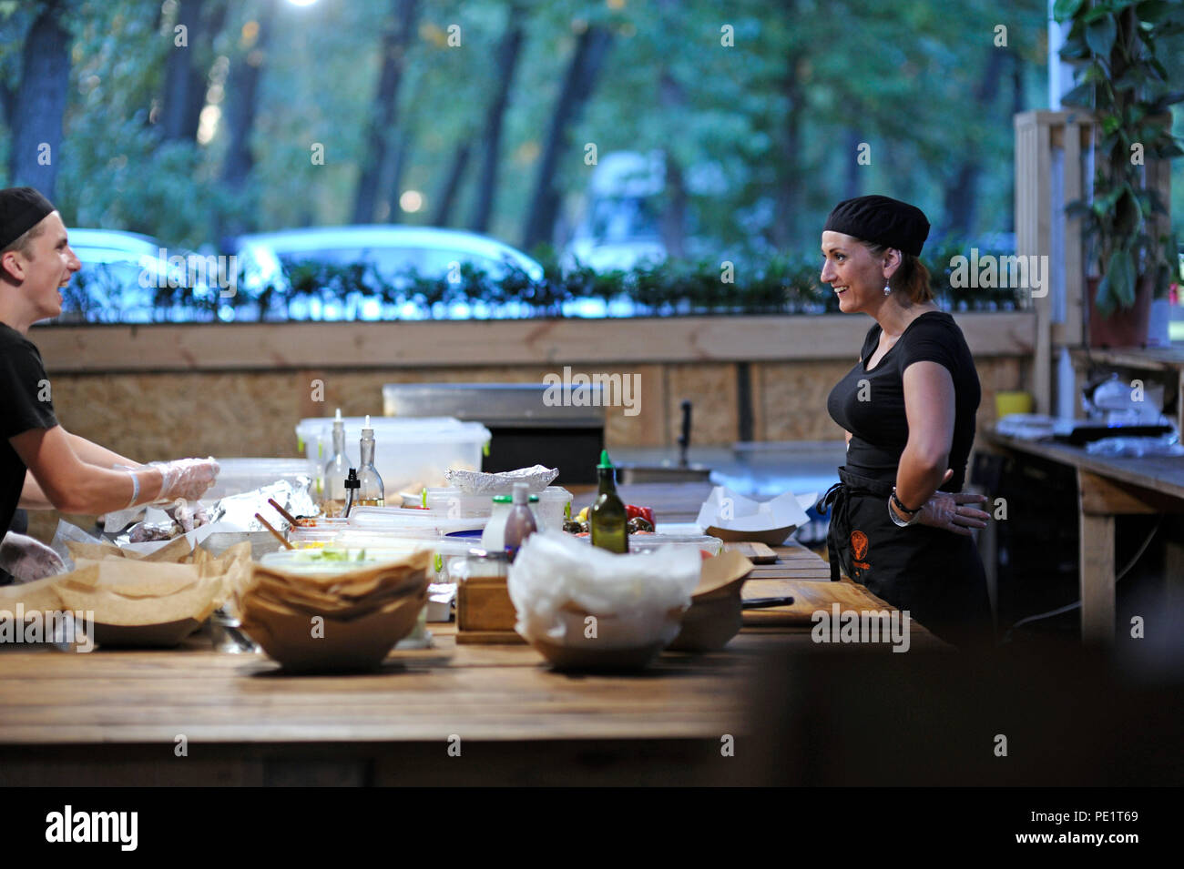 Les cuisiniers communiquent tout en préparant des repas rapides sur une table de cuisine d'un restaurant. 25 juillet 2018. Kiev, Ukraine Banque D'Images