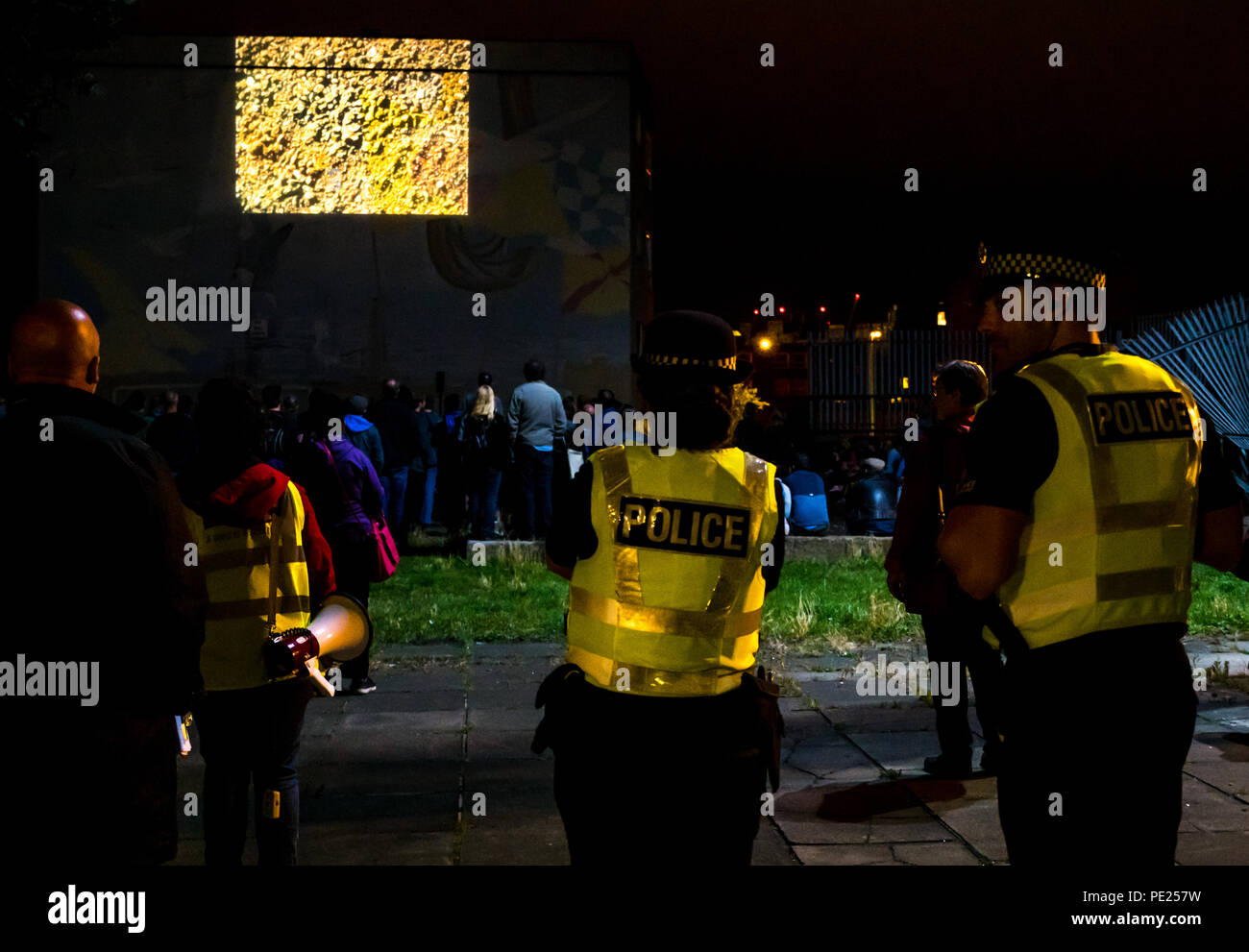 Ecosse, Royaume-Uni. 11 août 2018. Leith, Edinburgh Flinge Festival, événement extérieur, Ecosse, Royaume-Uni. Un mur est Un Écran: Promenade guidée gratuite de court-film avec des projections extérieures spécifiques au site sur les murs des bâtiments dans une visite de cinq emplacements dans les rues arrière de Leith. Les emplacements comprenaient un bloc de logements sociaux Linksview, Water Street et The Shore. La police communautaire a escorté la foule et a signalé qu'environ 600 personnes ont assisté à l'événement Banque D'Images