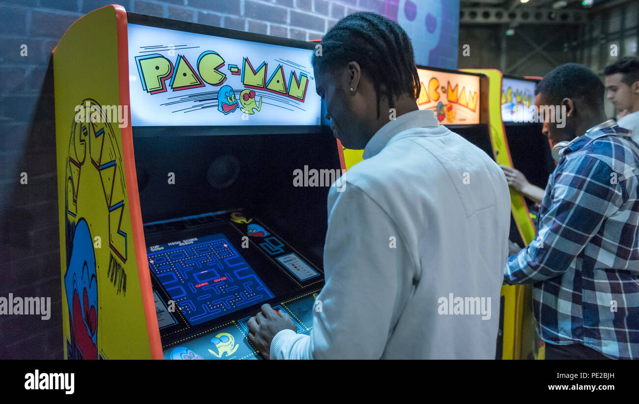 Londres, Royaume-Uni. 12 août 2018. Visiteurs jouent à des jeux Pac-Man rétro festival jouer de l'Expo à Londres pour la première fois à l'eau du Canada, The Printworks. Les amateurs de jeu à visité Redécouvrez les classiques, de Donkey Kong, Pong, Super Mario Bros. et Space Invaders à vintage flippers, jeux indépendants, VR et une zone de Minecraft. Le spectacle comprenait également un avant-goût du nouveau service de streaming de jeux rétro, Antstream. Crédit : Stephen Chung / Alamy Live News Banque D'Images