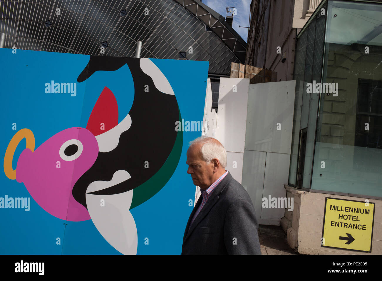 L'homme marche dernières illustrant la thésaurisation d'une partie de l'inscription contemporaine les armoiries de Glasgow, inn Glasgow, Ecosse, le 8 août 2018. Banque D'Images