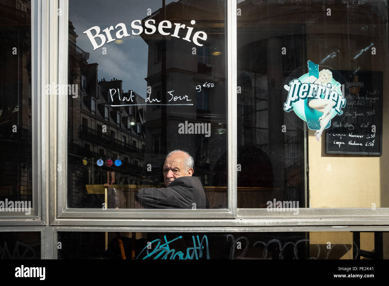 Un homme plus âgé assis seul dans une brasserie à Paris, France Banque D'Images
