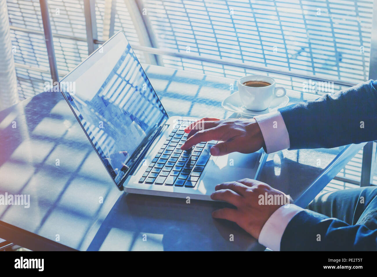 Businessman working on computer dans l'aéroport, la banque en ligne sur internet, la rédaction de courrier électronique, les mains de taper au clavier Banque D'Images