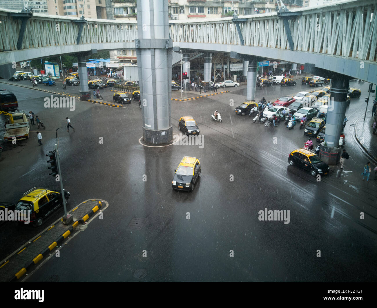 La circulation en pluies de mousson chez Nana Chowk avec une passerelle pour piétons au-dessus, à Grant Road, Mumbai, Inde Banque D'Images