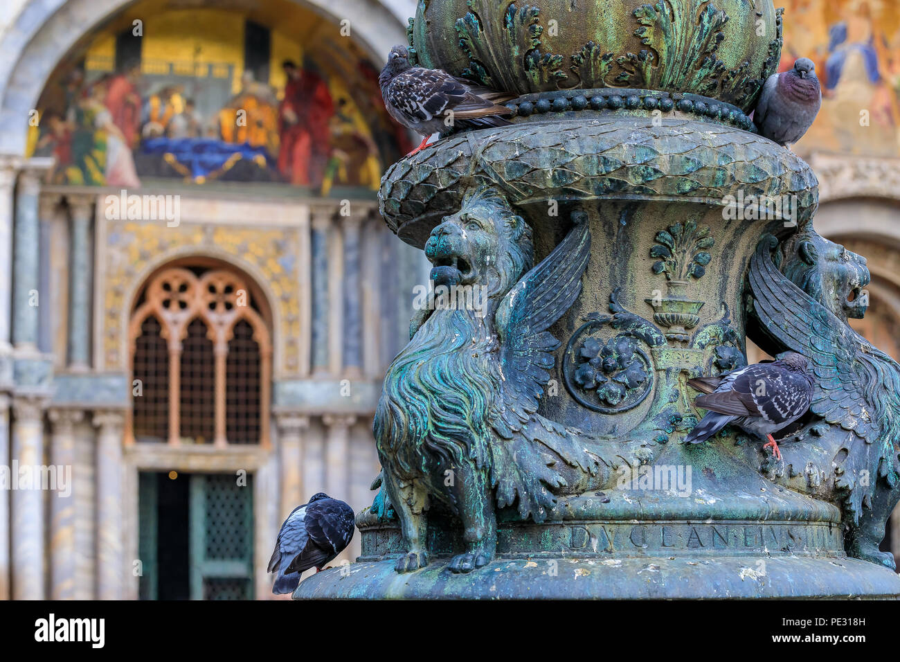Détail ornemental en forme de Lion de Saint Marc et les pigeons sur un luminaire en face de la Basilique Saint Marc sur Saint Marc (San Marco), carré Banque D'Images