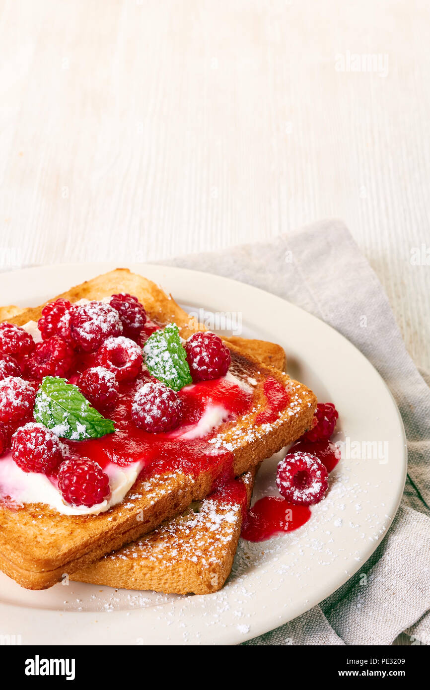 Petit-déjeuner sain avec toast et framboises sur table en bois Banque D'Images