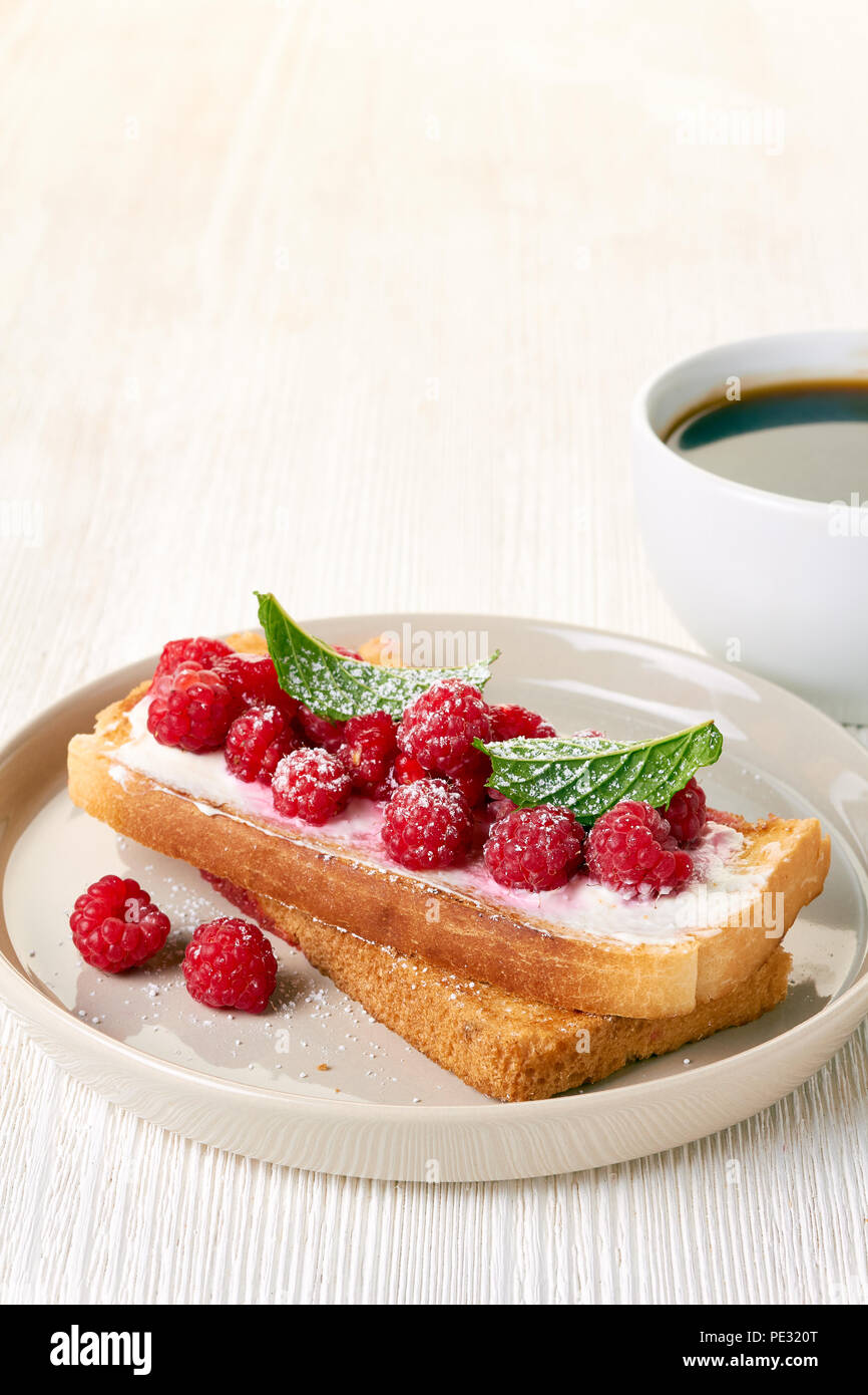 Café et des toasts avec les framboises sur tableau blanc Banque D'Images