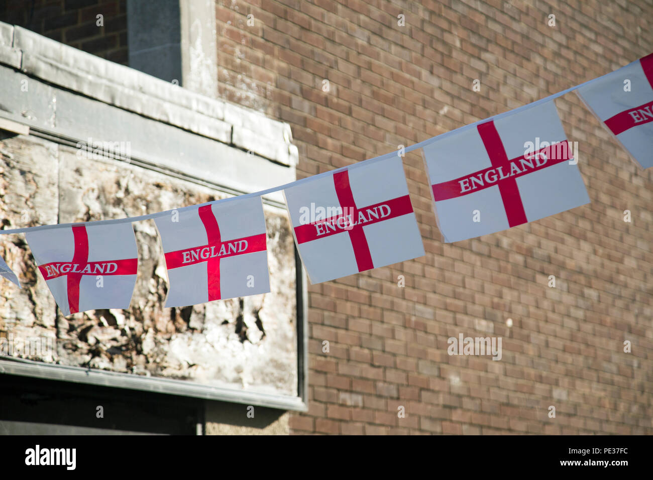 Une chaîne de l'Angleterre en plastique avec des drapeaux de la détérioration d'une boutique de signe derrière Banque D'Images