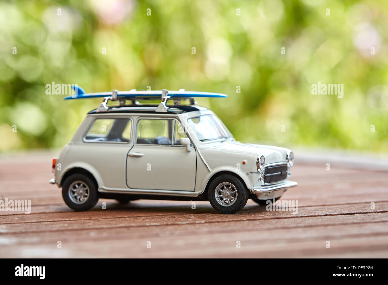 Mini voiture jouet avec sufboard sur le toit du prince pour des vacances sur la plage Banque D'Images
