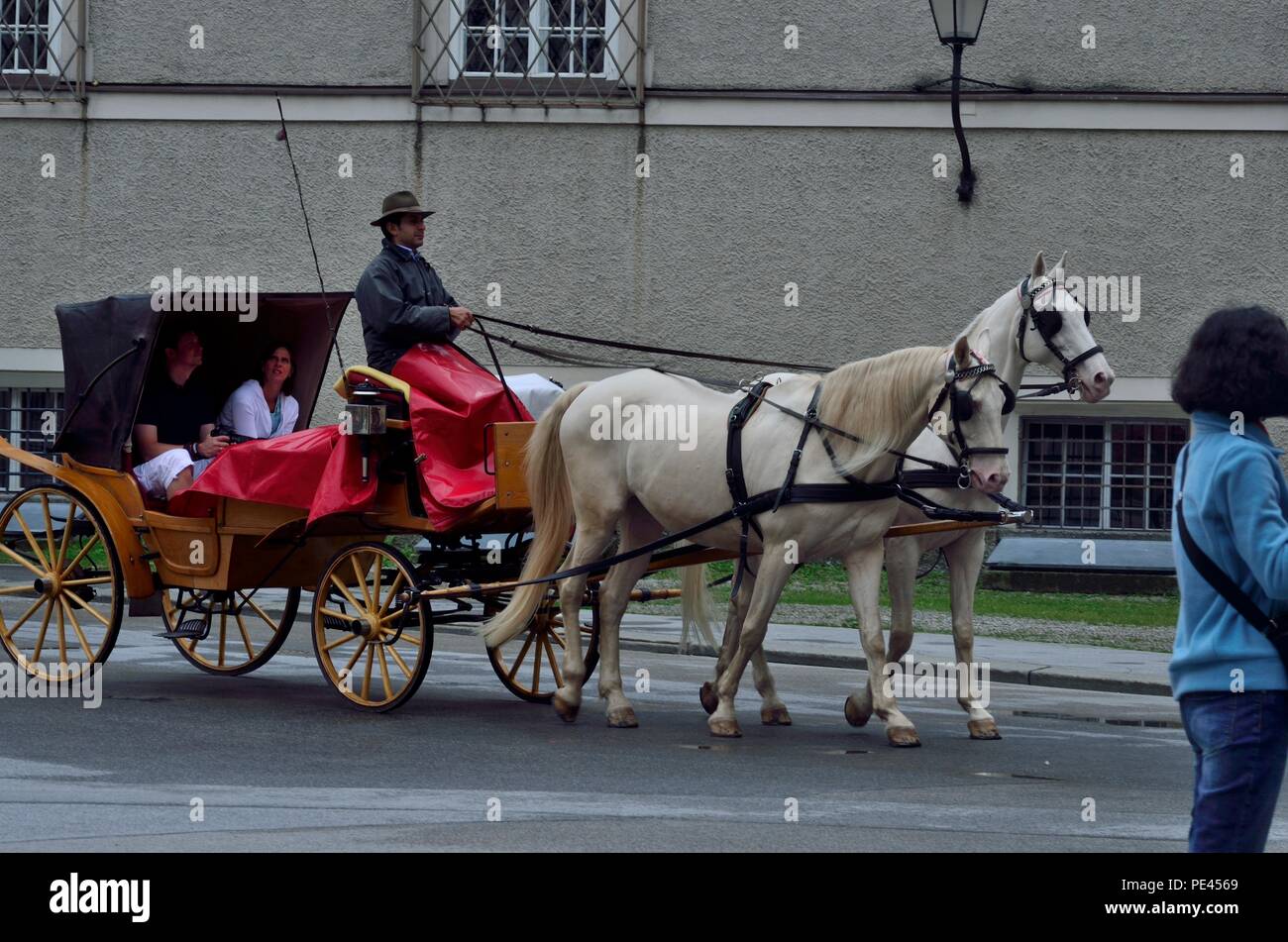 Une voiturette à cheval avec passagers, en traversant la célèbre cathédrale de Salzbourg, Autriche, Europe Banque D'Images