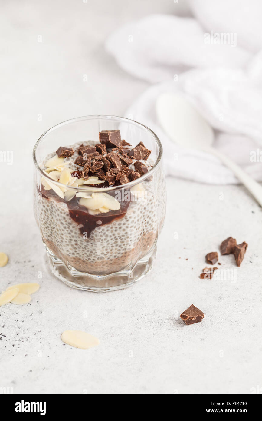 Chia pudding au chocolat, amandes et confiture de petits fruits, fond blanc. Dessert végétalien premières. Concept de l'alimentation propre. Banque D'Images