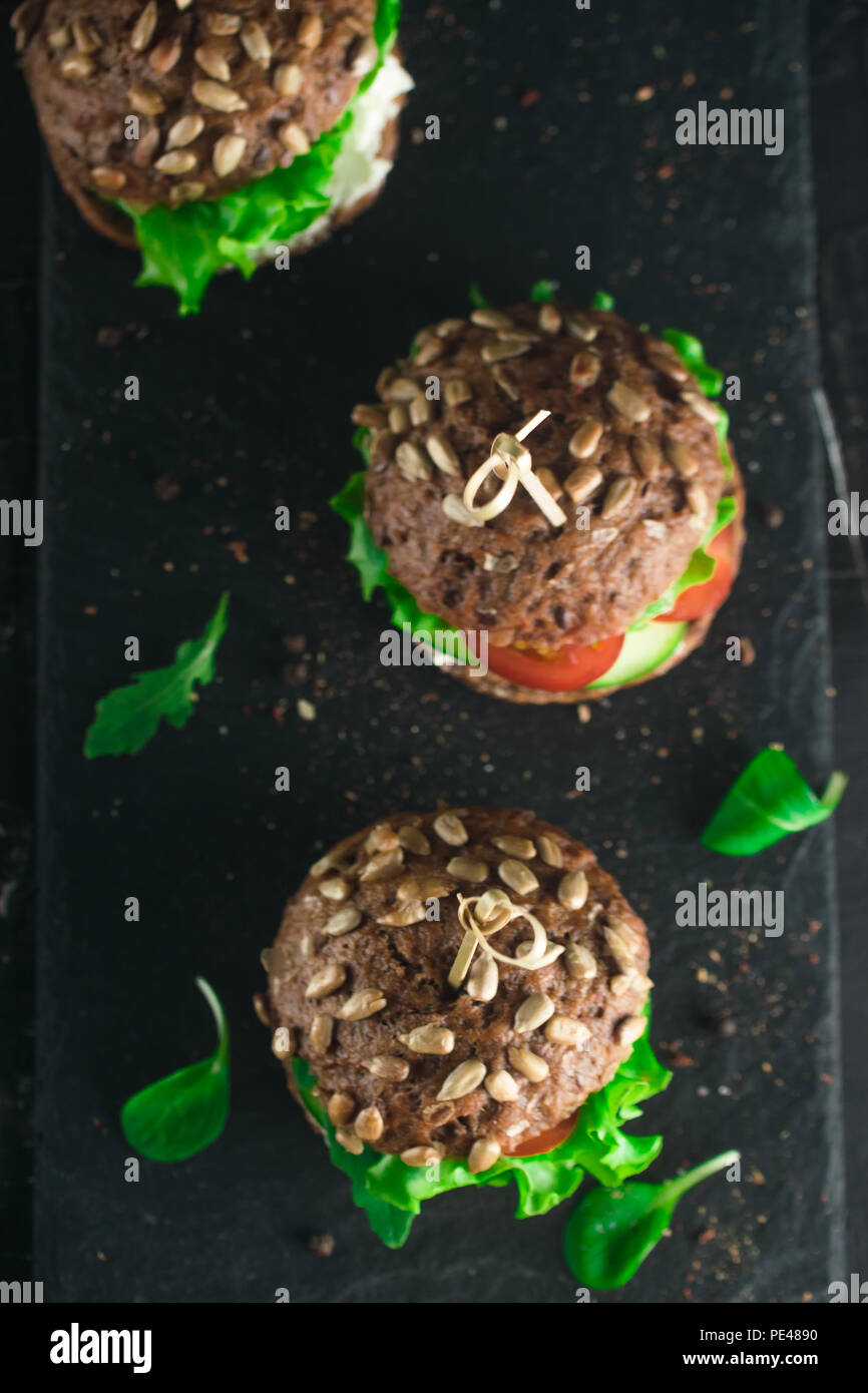 Sandwich avec salade verte, tomates, concombres et fromage à la crème sur le béton 24. Banque D'Images