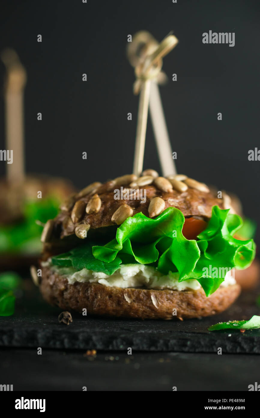 Sandwich avec salade verte, tomates, concombres et fromage à la crème sur le béton 24. Banque D'Images