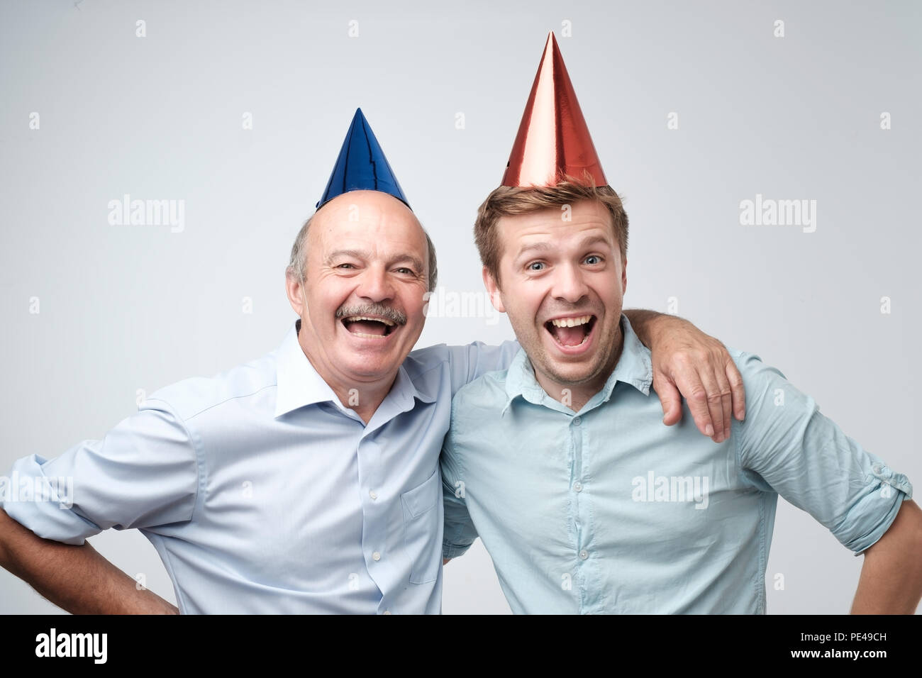 Homme mûr et son jeune fils fête joyeux anniversaire portant des chapeaux  drôles. Célébrer l'anniversaire. Les travailleurs ont le plaisir après  l'achèvement d'un co Photo Stock - Alamy