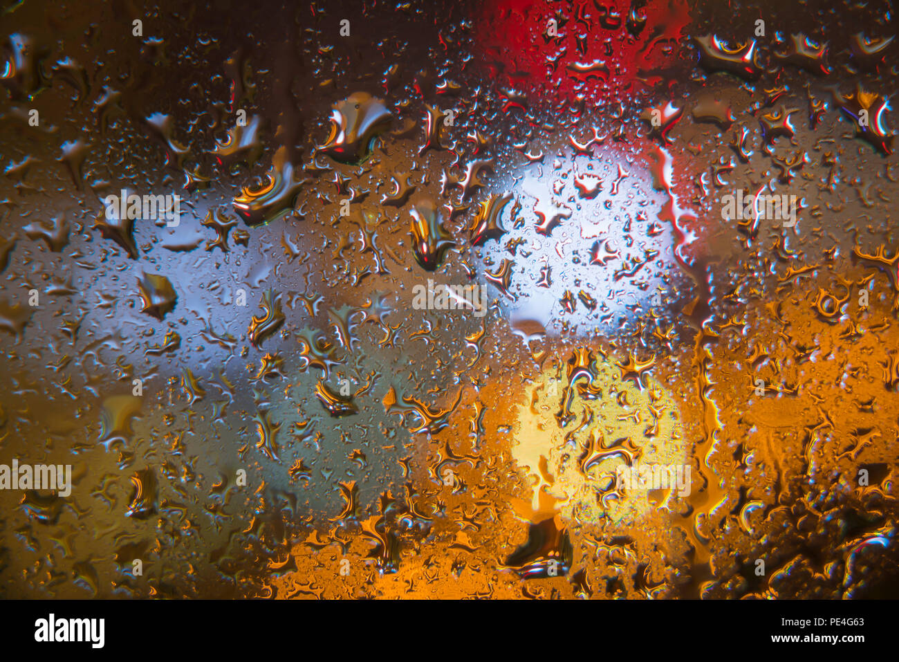 Gouttes sur la fenêtre avec l'arrière-plan flou coloré Banque D'Images