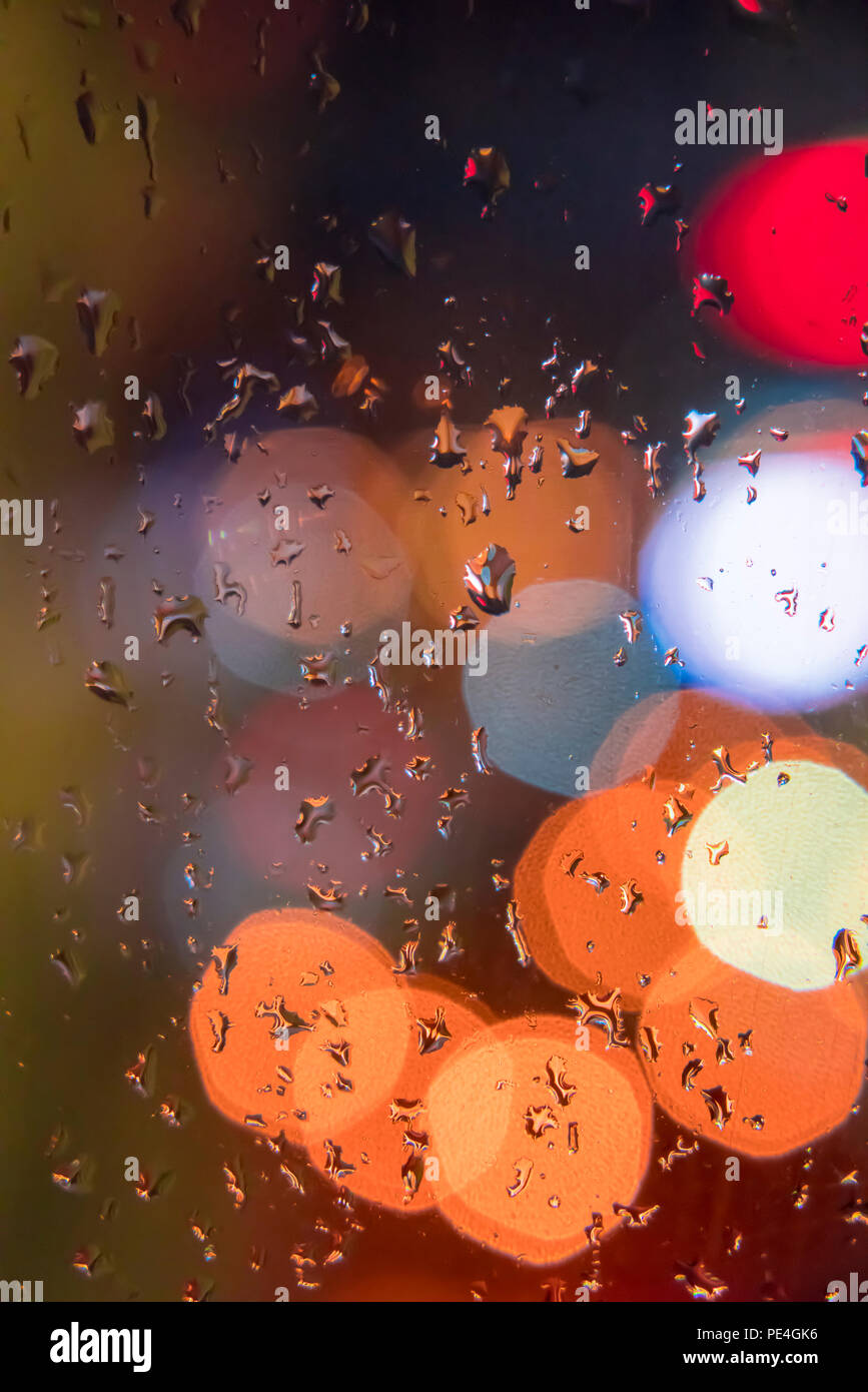 Gouttes sur la fenêtre avec l'arrière-plan flou coloré Banque D'Images