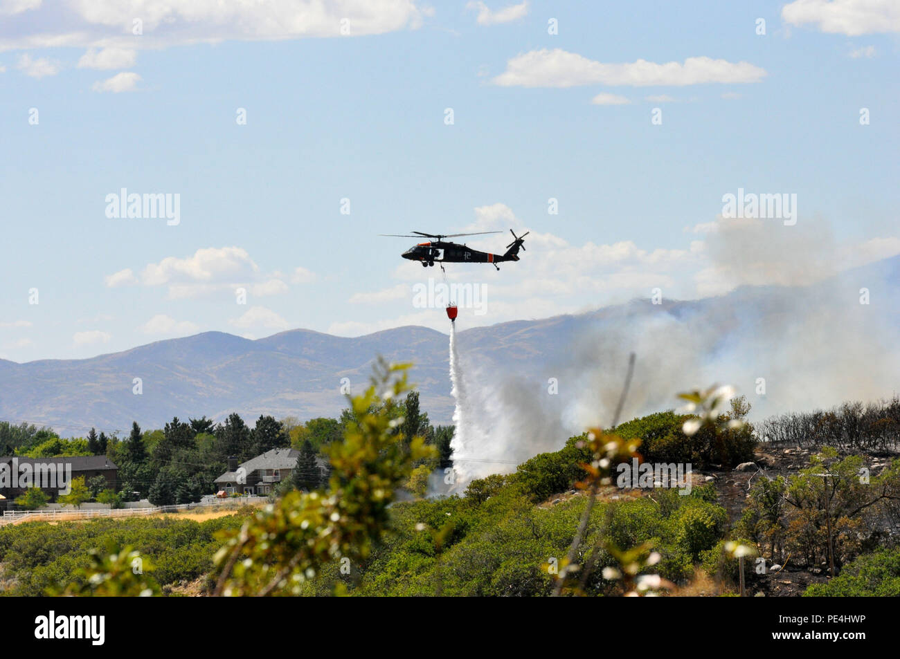 La Garde nationale de l'Utah a été activé afin de faciliter la lutte contre le feu sur l'incendie du 1er septembre Quail Hollow à Cottonwood Heights. Black Hawk pilotes, équipages et du personnel de soutien de la Garde côtière de l'Utah 2-211e a répondu à l'appel de l'Aviation à court préavis, de répondre avec deux hélicoptères UH-60 Black Hawk pour aider à combattre le feu de l'air. Chaque hélicoptère fait plusieurs excursions aux sources d'eau pour rafraîchir ses 600-gallon seau et déposer l'eau sur les flammes. (Photo : Capt Ryan Sutherland) Banque D'Images