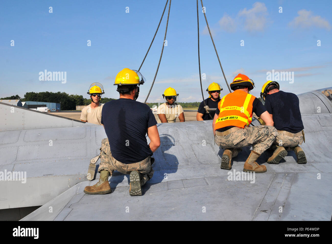 Les aviateurs de l'US Air Force à partir de la New Jersey Air National Guard 177e Escadre de chasse Mobilité Crash avion endommagé Recovery team work au crochet d'une grue d'un F-16 Fighting Falcon fuselage 19 Septembre, 2015 au Naval Air Station Wildwood Aviation Museum, New Jersey. Le CDDAR équipe a achevé la formation de levage de la grue, un tri-certification annuelle utilisée dans le cas où un aéronef immobile doit être retirée de la piste rapidement et en toute sécurité. (U.S. Photo de la Garde nationale aérienne Aviateur Senior Shane S. Karp / relâché) Banque D'Images