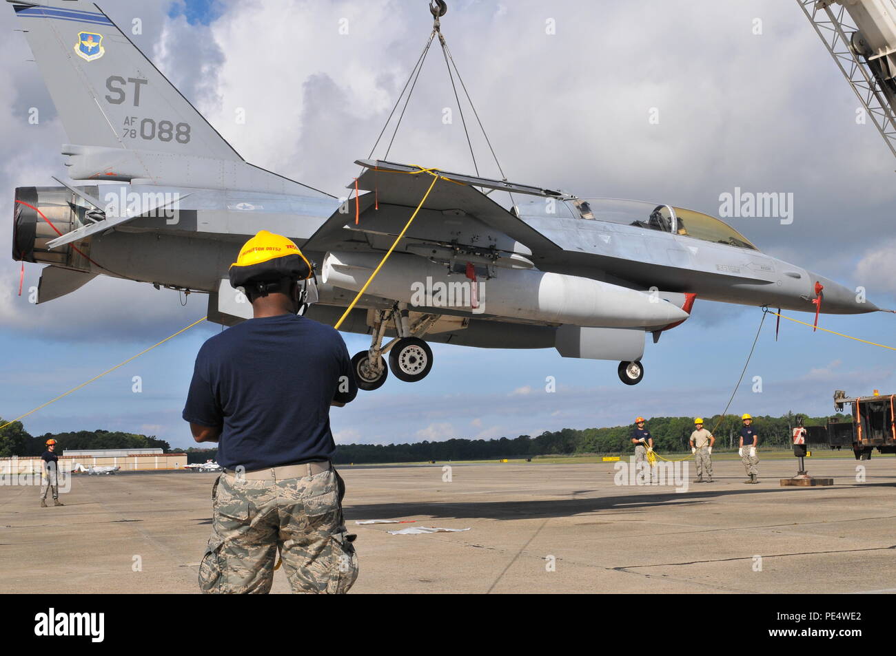 Les aviateurs de l'US Air Force à partir de la New Jersey Air National Guard 177e Escadre de chasse Mobilité Crash avion endommagé une manœuvre de l'équipe de récupération F-16 Fighting Falcon accroché à une grue ascenseur, le 19 septembre 2015, au Naval Air Station Wildwood Aviation Museum, New Jersey. Le CDDAR équipe a achevé la formation de levage de la grue, un tri-certification annuelle utilisée dans le cas où un aéronef immobile doit être retirée de la piste rapidement et en toute sécurité. (U.S. Photo de la Garde nationale aérienne Aviateur Senior Shane S. Karp / relâché) Banque D'Images