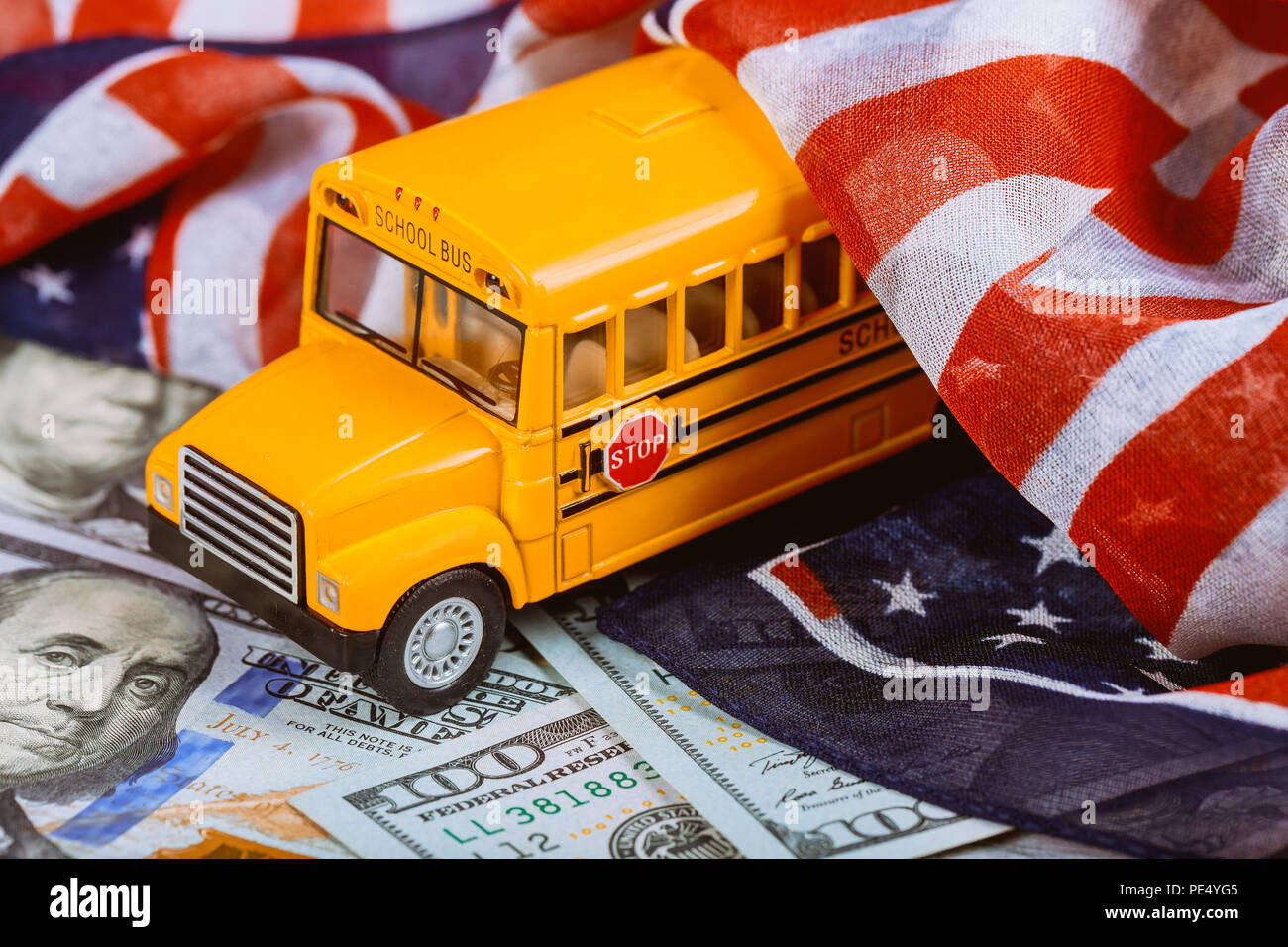 Drapeau américain et les billets de trésorerie en dollars US de l'argent et des autobus scolaires Close up Banque D'Images