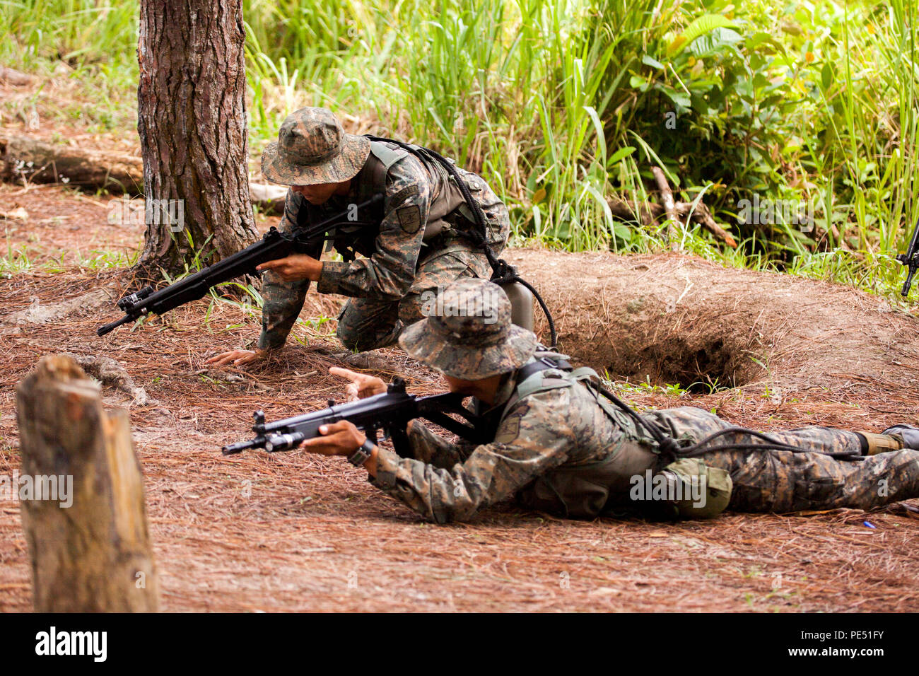 Les Marines et les soldats avec la Brigada de Infanteria Marina d'assurer la sécurité dans le cadre de l'application pratique de la partie d'un exercice de patrouille pendant un cours de combat urbain menée par les Marines américains de la coopération en matière de sécurité, Team-Guatemala Objet Spécial Groupe Force-Southern air-sol marin, commande à Puerto Barrios, Guatemala, le 24 septembre, 2015. SPMAGTF-SC est un déploiement temporaire de marines et marins dans tout le Honduras, El Salvador, Guatemala, Belize et en mettant l'accent sur la création et le maintien de la capacité de partenariat avec chaque pays à travers des valeurs communes, des défis et responsabilités. (U Banque D'Images