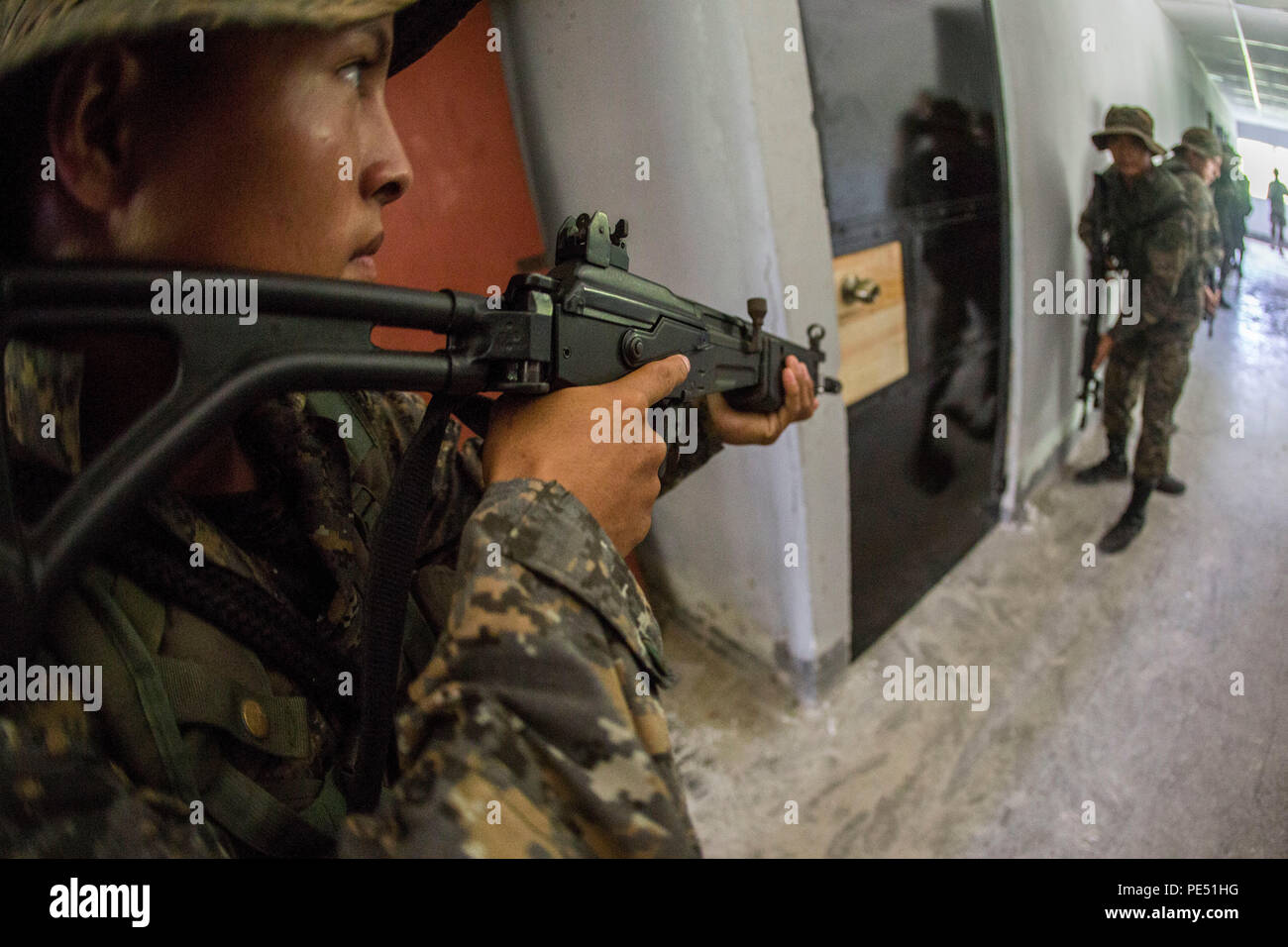 Les Marines et les soldats avec Brigada de Infanteria Marina préparer à ouvrir une porte et d'une chambre claire dans le cadre d'opérations urbaines formation pendant un cours combat urbain menée par les Marines américains avec la coopération de sécurité, Team-Guatemala objet spécial air-sol marin le Commandement Sud de l'Équipe spéciale à Puerto Barrios, Guatemala, 25 septembre 2015. SPMAGTF-SC est un déploiement temporaire de marines et marins dans tout le Honduras, El Salvador, Guatemala, Belize et en mettant l'accent sur la création et le maintien de la capacité de partenariat avec chaque pays à travers des valeurs communes, des défis et responsabilités. (U.S. Marine Co Banque D'Images